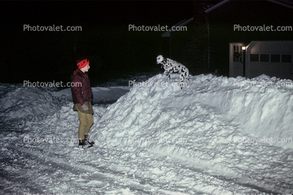 Dalmatian on a snow mound, man, coat, hat