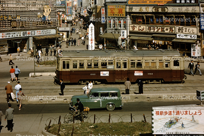 Trolley, cars, buildings, billboards, 1950s