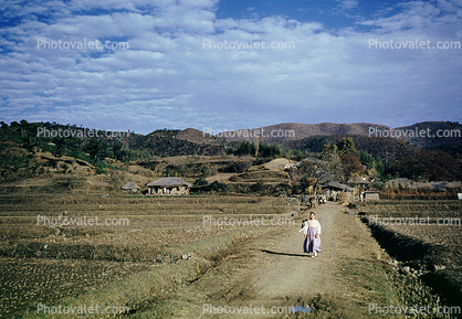 Woman walking down the road, hills, buildings, town, village, near Pusan, South Korea, 1952