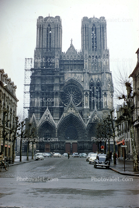 Front facade of a Cathedral, scaffolding, cars, 1950s