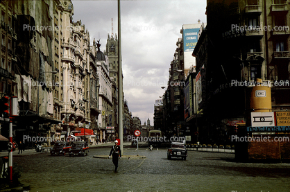 Cars, buildings, cobblestone street, 1950s