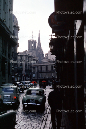 Cars, cobblestone street, buildings