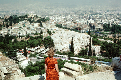 Woman overlooks the city of Athens, smog, haze