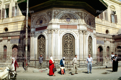 ornate building, doorway, railing, sidewalk, women, men, opulant