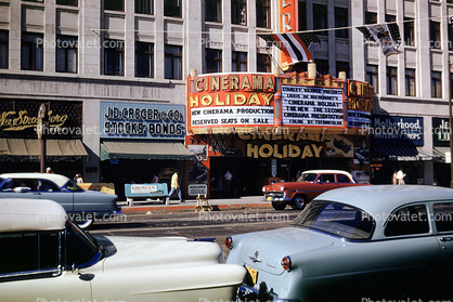 Cinerama Holiday, Motherhood Maternity Shops, marquee, J.D. Creger & Co. Stocks and Bonds, cars, street, Ford, 1955, 1950s