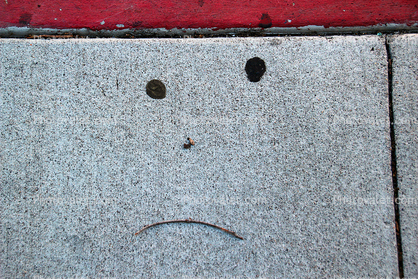Pareidolia, sad face on a sidewalk