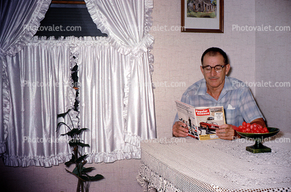 Man reading Popular Mechanics, 1950s