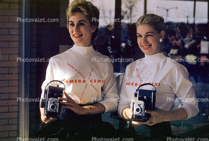 Pretty ladies holding a Polaroid Camera, 1950s