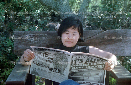 Asian Woman reads a Tabloid, It's Alive
