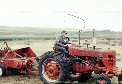 Farmer on Tractor with Hay Baler Trailer, buncher, 1950s