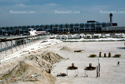 Terminal, building, baggage carts, dirt mounds