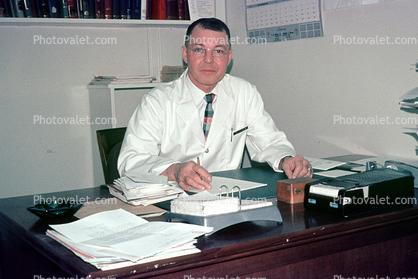 Doctors Office, man, male, desk, ashtray, calendar, paperwork, paper, 1950s