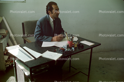 Teacher, Man, Male, Table, Chair, Sitting, Classroom, Schoolroom, Desk, Afghanistan, 1974, 1970s