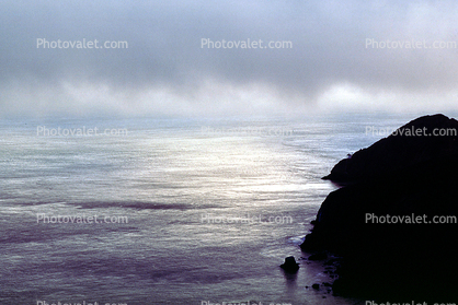low hanging rainy clouds, fog, pacific ocean, shoreline