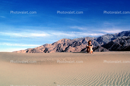 Woman sitting, Sand Dunes, Death Valley National Park, Panamint Mountain Range