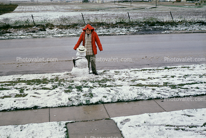 Boy with his small snowman, sidewalk, road, coat, hat, jacket, 1950s