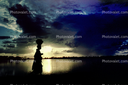 Woman Walking in the Sunset, Clouds, Lake