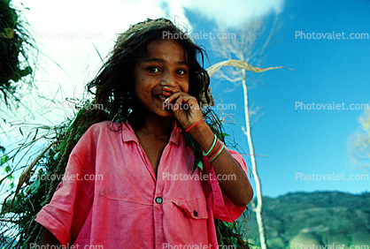 Smiling Girl carrying vegetation, Deforestation