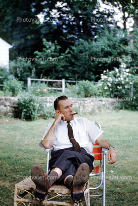 cigar smoking, man, lounging, pants, shoes, tie, backyard, 1950s