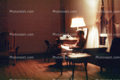 Lamp, chair, man reading, Burklyn Hall Burke, Vermont, 1978, 1970s