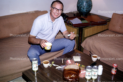 Man, Smiling, sofa, couch, eathing, coors beer cans, table, cup, glasses