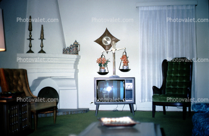 Television Screen, fireplace, curtains, chairs, scale, clock