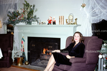 Smiling Lady Sitting, mantle, fireplace, curtains, Christmas decorations, 1950s
