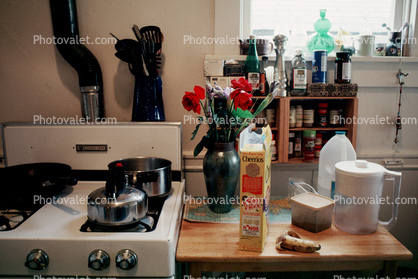 stove, counter, spices, cereal box, banana, water container