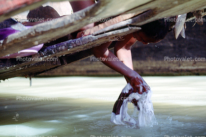 washing clothes from the front of a boat, Mopti, Mali