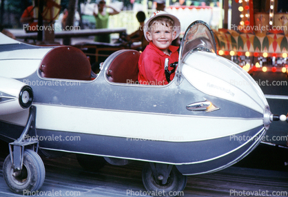 Boy in a jet fighter plane, smiles, Fair Ride, July 1970