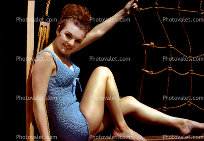 Lady in a one piece bathing suit, leggy, beehive hairdo, smiles, 1950s
