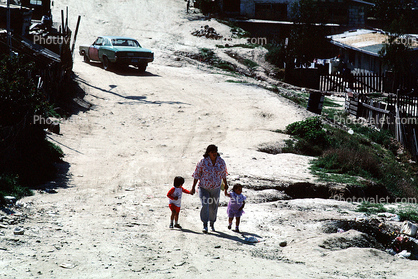 mother, children, walking, car, dirt street, Colonia Flores Magone