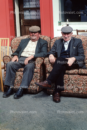 two men sitting on a sofa