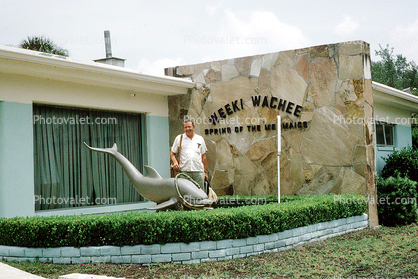 Weeki Wachee, Florida, Dolphin, building, man, bush, wall, 1973