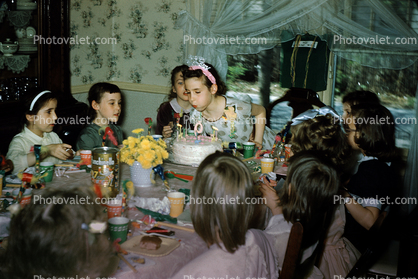 Girl Celebrating being Nine Years Old, blowing out candles, cake, tiara, 1950s