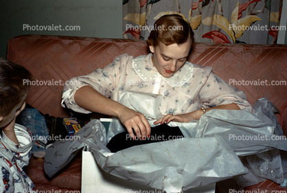 Pretty Lady opens a present, gift, sofa, unwrapping presents, 1950s