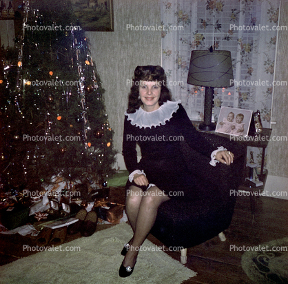 Pretty Smiling, Woman sits, RHT stockings, lamp, tree, 1940s