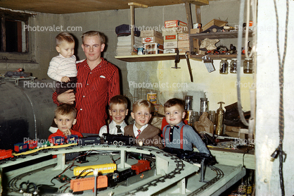 Boys with their Christmas model train set, basement, 1950s