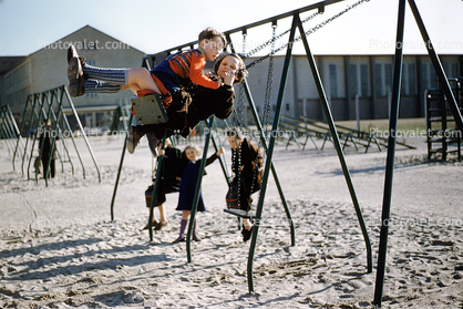 Swingset, swings, girl, boy, sand, 1940s