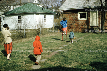Girl on Stilts, backyard, coats, cold winter, Mother with Movie camera, 1950s