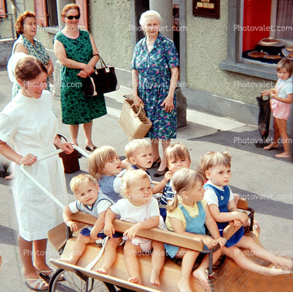Nurse Maid, cart full of kids, boys, girls, barefeet, barefoot, Hergiswil Switzerland, August 1970, 1970s