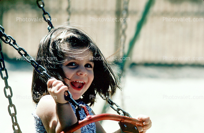 Girl on a swing, smiles, joy