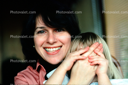 smiling mom playing with daughter