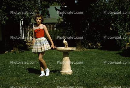 Girl in the Backyard, skirt, grass, lawn, birdbath, 1950s