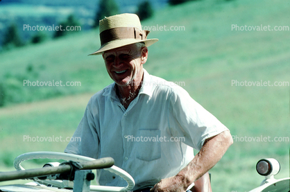Smiling man with his tractor, Burklyn, Burke, Vermont, 1970s