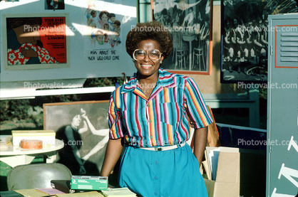 Smiling Black Woman at a Booth at Festival at the Lake