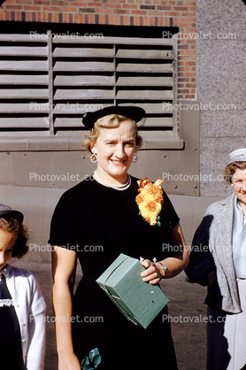 Woman wearing a corsage, flower, smiles, hat, 1950s