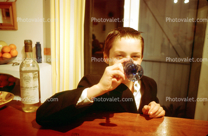 young boy drinks hard liquor