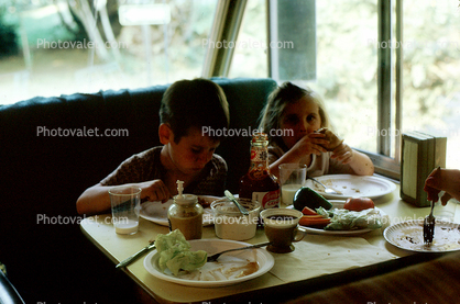 Brother and Sister eating lunch in an Recreation Vehicle