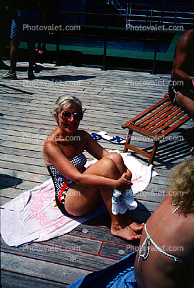 Woman Sitting on a Dock, sun tan, burn